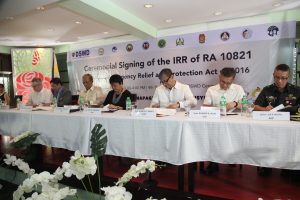 Photo caption (middle, left to right): Department of Social Welfare and Development (DSWD) Secretary Judy M. Taguiwalo signs the Implementing Rules and Regulations (IRR) of the Children’s Emergency Relief and Protection Act with Save the Children Country Director Ned Olney, Department of Health (DOH) Undersecretary Gerardo Bayugo, Department of National Defense (DND) Secretary Delfin Lorenzana, Department of Education (DepEd) Undersecretary Alberto Muyot, Office of Civil Defense (OCD) administrator Undersecretary Ricardo Jalad, and Armed Forces of the Philippines-Human Rights Office (AFP-HRO) chief B/Gen. Jose Antonio Carlos Motril.