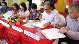 From left to right: Davao Regional Medical Center (DRMC) Chief Dr. Bryan O. Dalid, DSWD Protective Services Bureau (PSB) Director Alicia Bonoan, DSWD Field Office XI Regional Director Mercedita P. Jabagat, Secretary Judy M. Taguiwalo, Southern Philippines Medical Center (SPMC) Chief Dr. Leopoldo J. Vega, and Chief Administrative Officer Ricardo S.D. Justol sign the Memorandum of Agreement (MOA) for the implementation of "Lingap Sa Masa" medicine assistance program for indigent patients at SPMC and DRMC. 